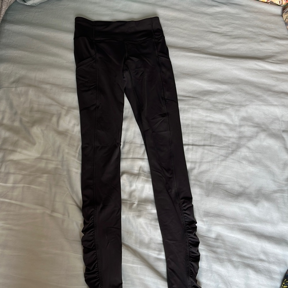 Black lululemon leggings with ruffles on bottom.